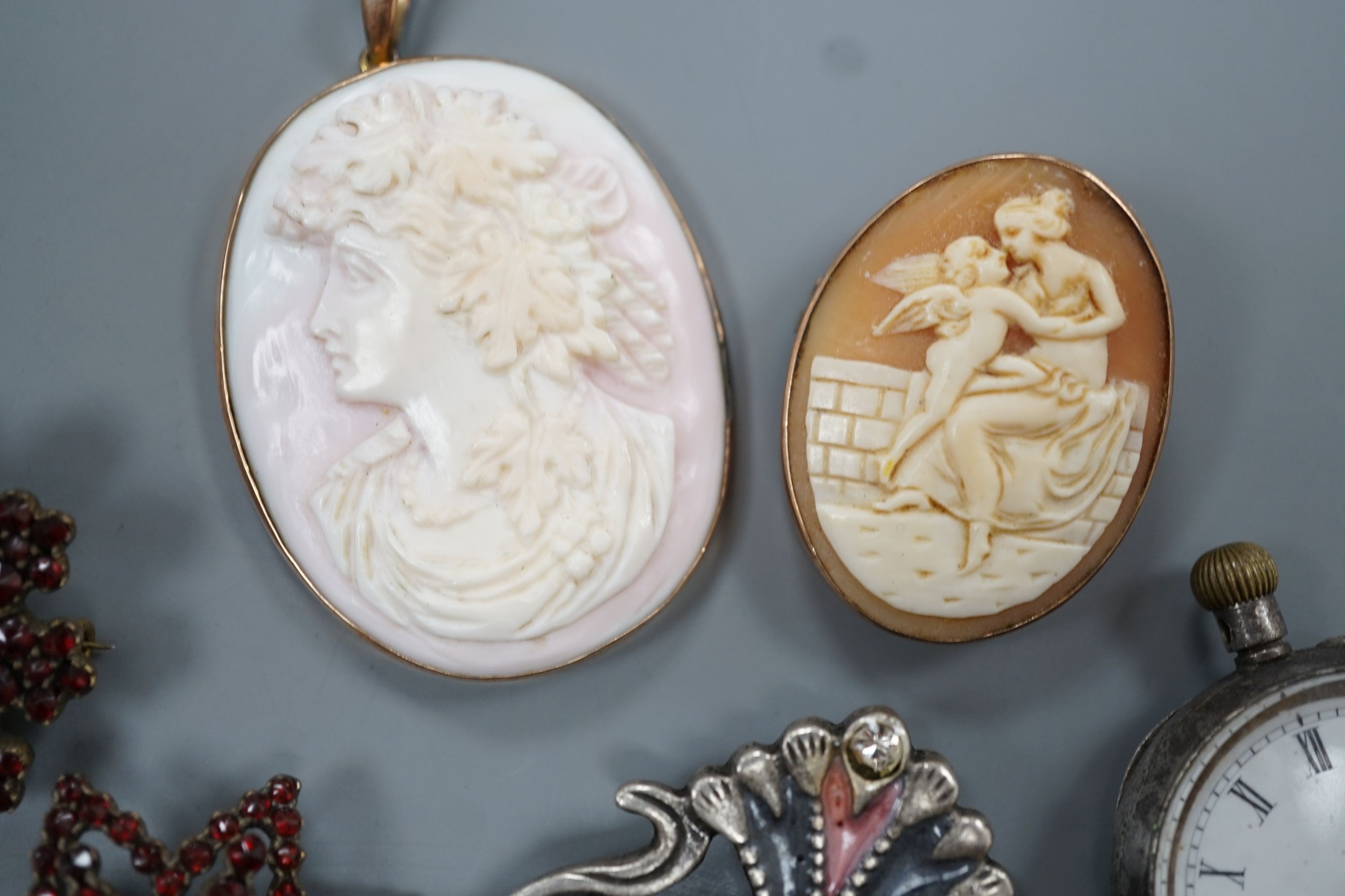 A yellow metal mounted cameo shell brooch and a similar pendant, two brooches, a white metal fob watch and one other brooch.